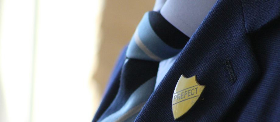 school uniform with prefect badge and tie